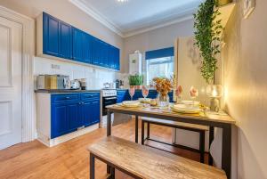 a kitchen with blue cabinets and a wooden table at Lovely 2 bedroom apartment - Sleeps 9 in Bristol