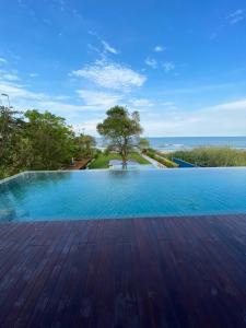 uma piscina com vista para o oceano em Beach Front Condo, Baan Thew Talay, Perfect Choice for Family and Couple em Ban Bo Khaem