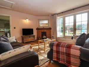 a living room with two couches and a fireplace at Rookery Cottage in Saxmundham