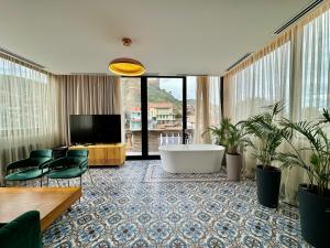 Großes Zimmer mit einer Badewanne und einem TV. in der Unterkunft Abanotubani Boutique hotel in Tbilisi City