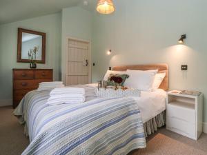 a bedroom with a bed with towels on it at Rookery Cottage in Saxmundham