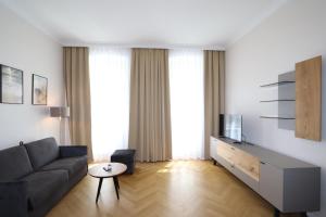 uma sala de estar com um sofá e uma televisão em Stylish City Center Apartment em Viena