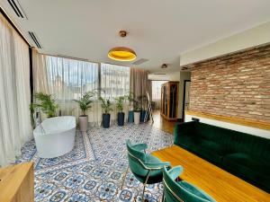 un salon avec un canapé vert et des plantes dans l'établissement Abanotubani Boutique hotel, à Tbilissi