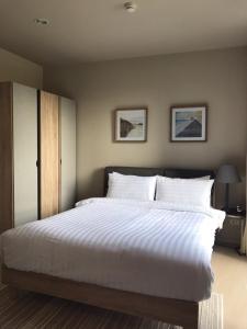 1 dormitorio con 1 cama grande con sábanas blancas en Beach Front Condo, Baan Thew Talay, Perfect Choice for Family and Couple, en Ban Bo Khaem