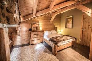 - une chambre avec un lit dans une cabane en bois dans l'établissement Chalet Pomet, à Morillon