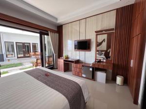 Grand Yuna Hotel Nusa Penida في Toyapakeh: غرفة نوم بسرير كبير وتلفزيون