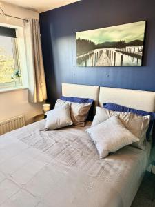 um quarto com uma cama grande e paredes azuis em 3 Bed Home for Contractors & Relocators with Parking, Garden & WiFi 30 mins to Alton Towers em Stoke on Trent