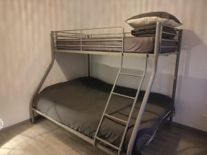 a metal bunk bed with pillows on top of it at La petite maison in Mesnil-Saint-Nicaise