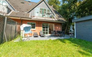 Cette maison dispose d'un patio avec des chaises et une terrasse. dans l'établissement Nordsee-Flair, à Böhl