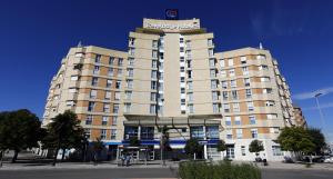 wysoki budynek z znakiem na górze w obiekcie Travelodge Madrid Coslada Aeropuerto w mieście Coslada