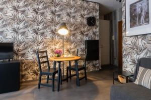 een tafel en stoelen in een woonkamer met een muur bij Villaggio Tranquillo - bambnb in Vinovo