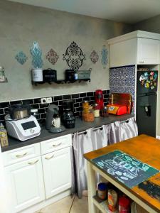 a kitchen with white cabinets and a counter top at Villa piscine proche Futuroscope in Buxerolles
