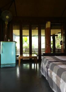 a bedroom with a bed and a table and windows at Pai Kiniman Resort in Pai