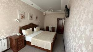 1 dormitorio con cama y pared en Altyn Adam Hotel en Petropavlovsk