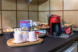 a kitchen counter with coffee cups and bread and a toaster at Villaggio Tranquillo - bambnb in Vinovo