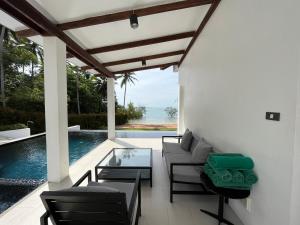 a patio with a table and chairs and a pool at Krabi Beach House, SHA Extra Plus in Ao Nam Mao