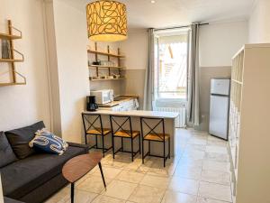 a living room with a couch and a kitchen at Suite Magelan in Villeurbanne