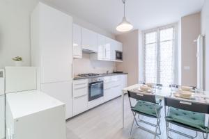 uma cozinha branca com armários brancos e um balcão em Crocetta District! Bright & Roomy Apartment em Turim