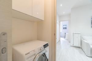 uma lavandaria com máquina de lavar e secar roupa em Crocetta District! Bright & Roomy Apartment em Turim