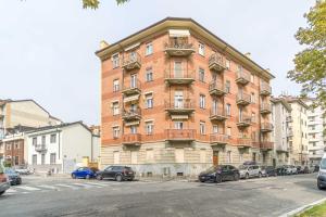 um grande edifício de tijolos com carros estacionados em frente em Crocetta District! Bright & Roomy Apartment em Turim