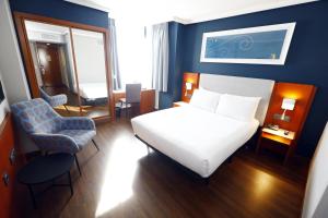 sypialnia z białym łóżkiem i niebieską ścianą w obiekcie Travelodge Madrid Coslada Aeropuerto w mieście Coslada