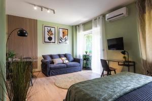 ein Wohnzimmer mit einem blauen Sofa und einem TV in der Unterkunft Villaggio Ippico - bambnb in Stupinigi
