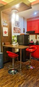 eine Küche mit roten Schränken, einem Tisch und Stühlen in der Unterkunft The Suites Metro by KS Property in Bandung