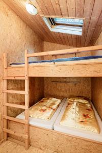 2 łóżka piętrowe w pokoju z sufitem w obiekcie Ferienpark Thüringer Wald w mieście Schalkau