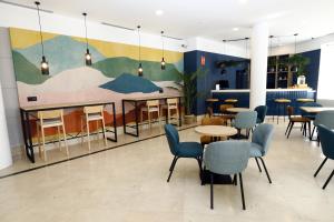 un vestíbulo con mesas y sillas y un mural en Travelodge Madrid Coslada Aeropuerto en Coslada