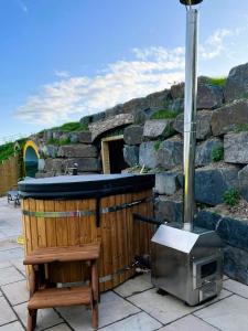 a hot tub and a television on a patio at Honeybee Home in Llansantffraid-ym-Mechain