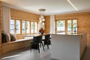 a kitchen with wooden walls and a table and chairs at Casa Mulania in Laax
