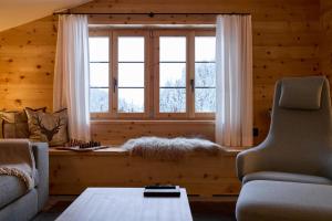 a living room with a couch and a window at Casa Mulania in Laax