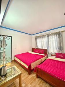 - 2 lits dans une chambre avec des draps roses dans l'établissement Thanh Dũng Hotel Sapa, à Sa Pa