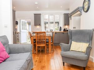 a kitchen and living room with a table and chairs at 3 Skaigh View Cottages in Okehampton