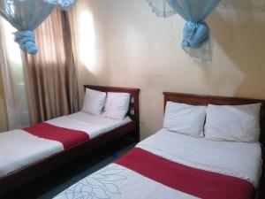 2 Betten nebeneinander in einem Zimmer in der Unterkunft Forest green Inn in Kakamega