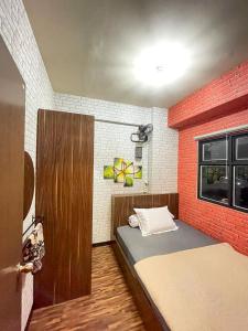 Zimmer mit einem Bett und einer Ziegelwand in der Unterkunft The Suites Metro by KS Property in Bandung