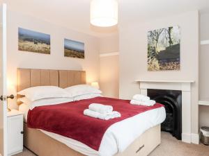 a bedroom with a bed with two towels at 3 Skaigh View Cottages in Okehampton