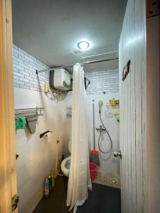 ein Bad mit einer Dusche und einem WC. in der Unterkunft The Suites Metro by KS Property in Bandung