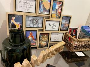 a table with a vase and a bunch of framed pictures at Appartement bleu l'union in Beausoleil