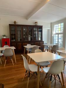 een groep tafels en stoelen in een kamer bij Just Joey Lodge in Stellenbosch