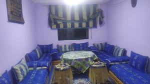 sala de estar con mesa y sofás azules en Tanger tanger tanja, en Tánger