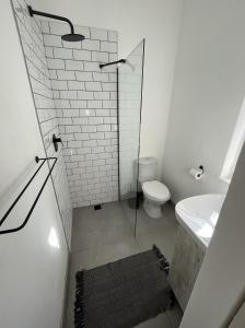 a white bathroom with a toilet and a sink at Rondebosch loft in Cape Town