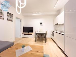 a living room with a table and a kitchen at Piazza della Borsa 3B Tirabora Short Rent in Trieste