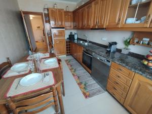 una pequeña cocina con armarios de madera y encimera en PISO MANCE en Allariz