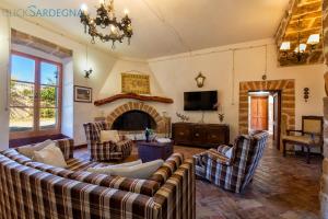 a living room with couches and a fireplace at Alghero prestigiosa antica dimora indipendente con piscina per 9 persone in Alghero