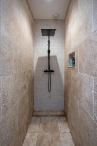 baño con ducha con una cruz en la pared en Le Bon Ami, en Fronsac