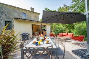 een patio met een tafel en een parasol bij Le Bon Ami in Fronsac