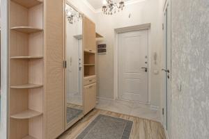 a walk in closet with a white door and shelves at Expo Promenade Уютная квартира возле Expo in Prigorodnyy