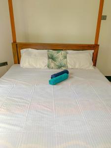 un objeto azul yace en una cama en Aldea bleu, en Midigama East