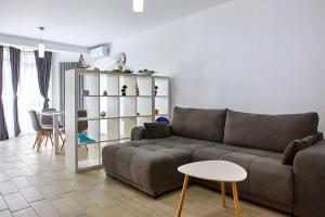 a living room with a couch and a table at Apartamente Indigo Alezzi Beach Pool & Spa in Mamaia Sat/Năvodari